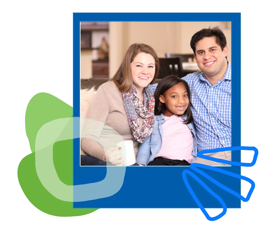 adoption-family-on-couch Two parents and a young girl smiling together on a couch