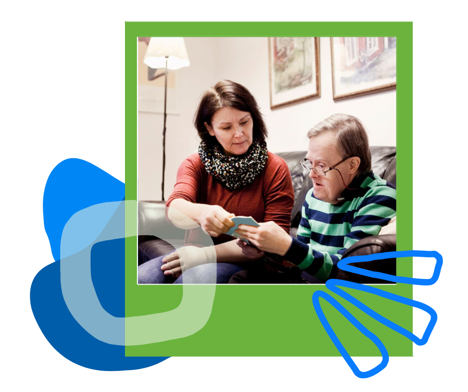 A woman in a red sweater sharing something on a card with an older man on a couch