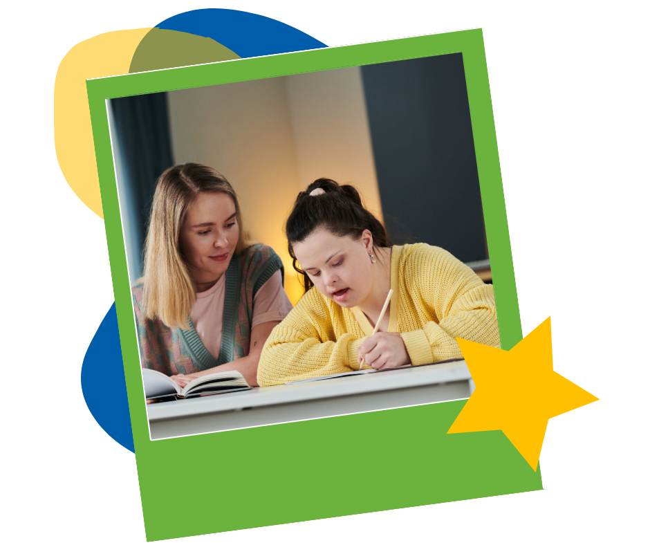 Two young women sitting at a table, one helping the other as she writes in a notebook