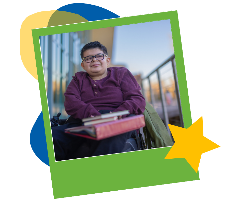 A smiling person in glasses and a maroon sweater, seated in a wheelchair with books on their lap