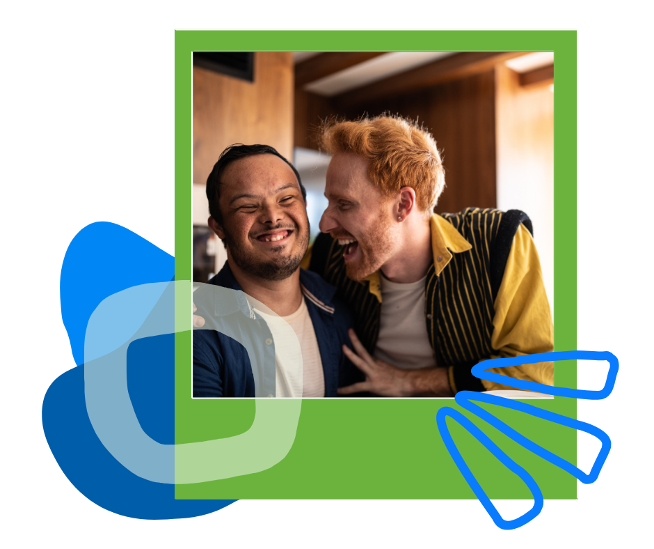 Two young men laughing together, one with an arm around the other’s shoulder