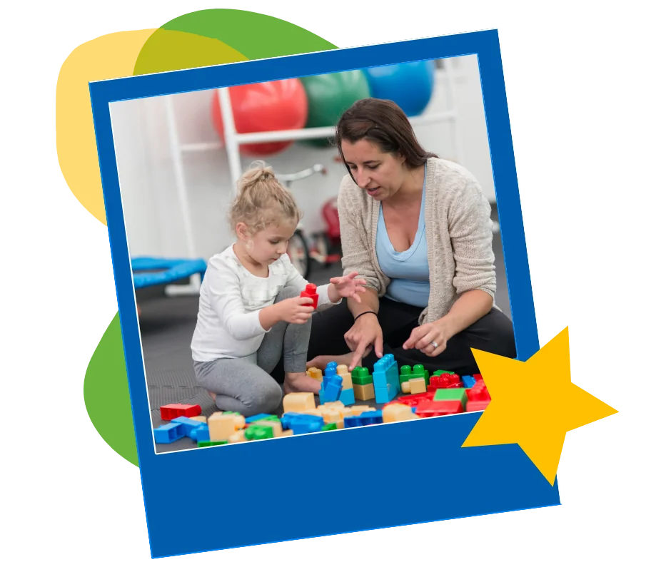 A therapist and a young child playing with blocks on the floor