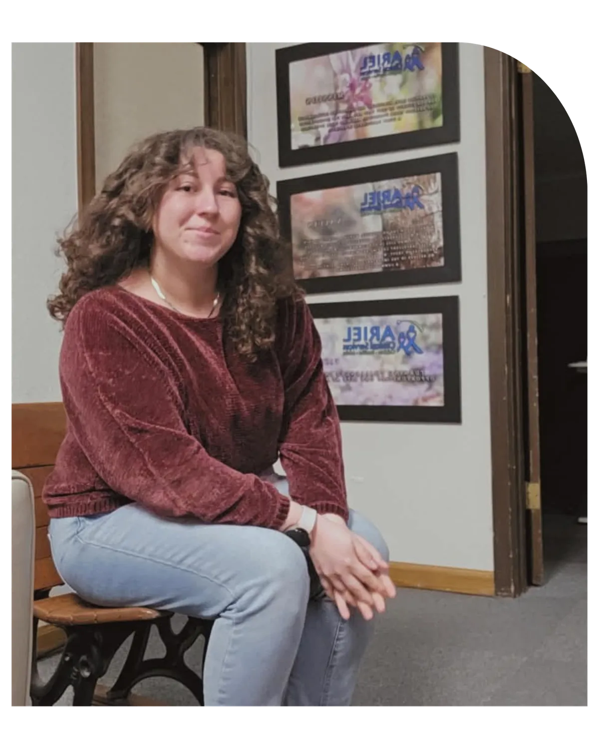 Staff member seated in the entry of Ariel’s Delta-Montrose office, framed awards on the wall