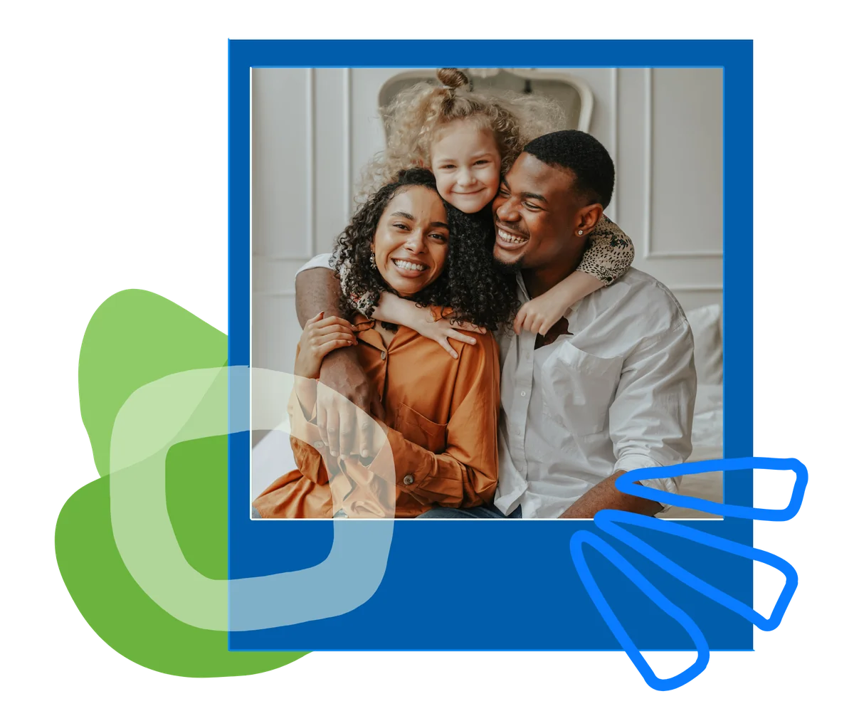 A young girl hugs a smiling man and woman from behind