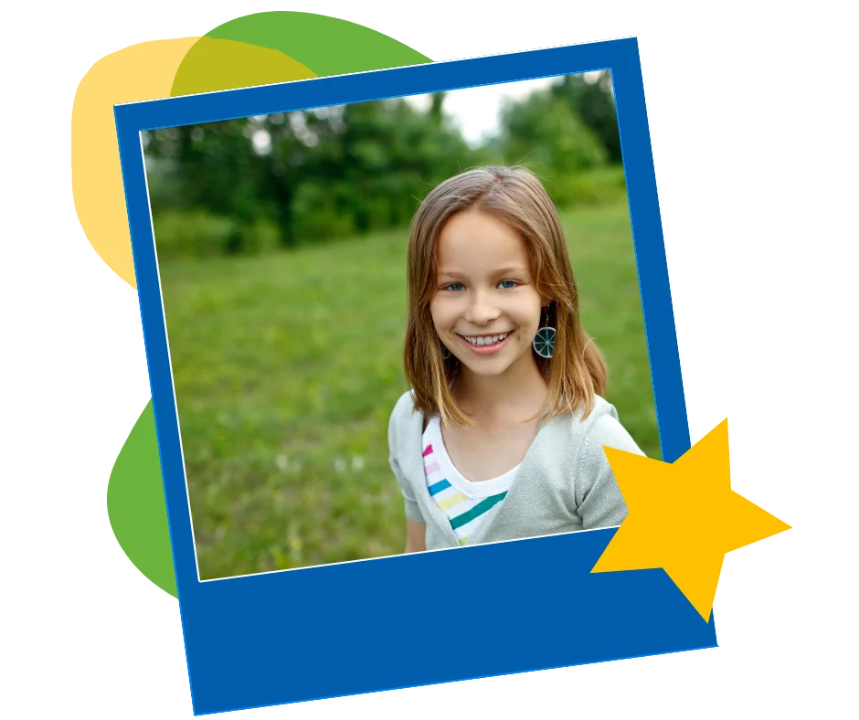 A smiling girl standing in a green field