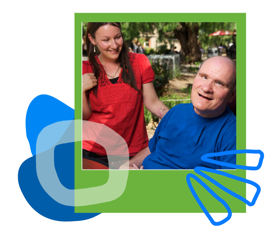 A woman in a red shirt and a man in a blue shirt smiling together outdoors