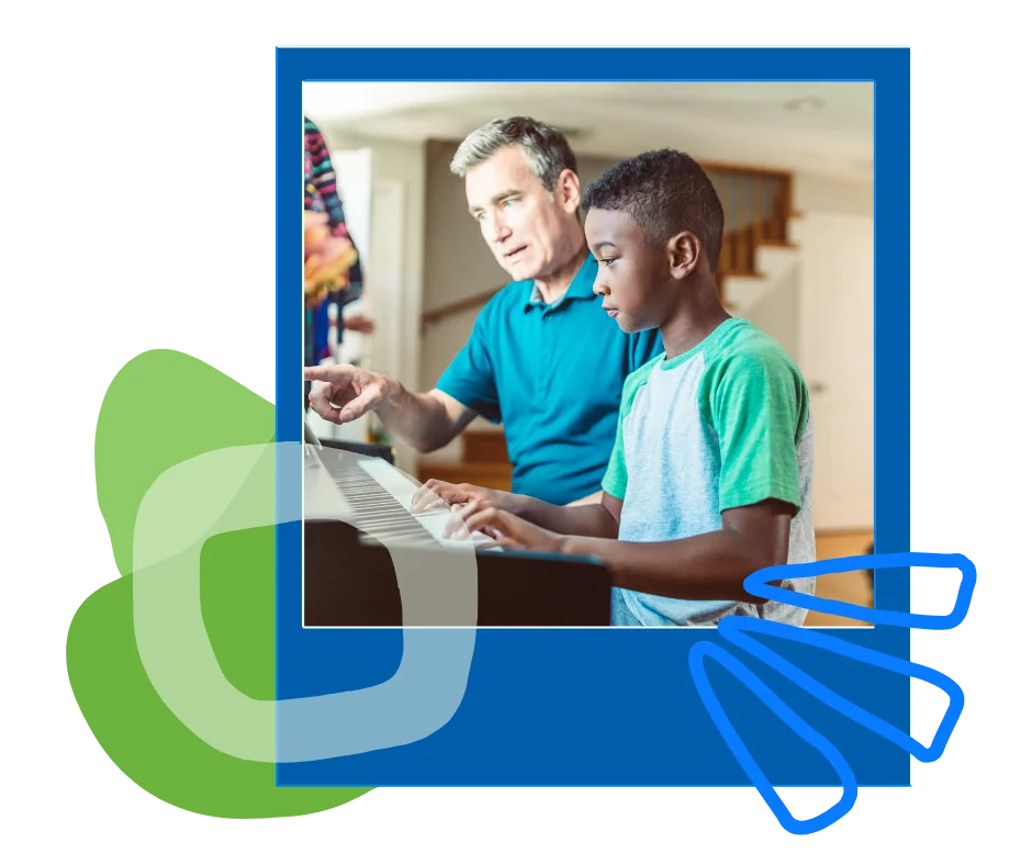 A man and a teenage boy working together at a piano